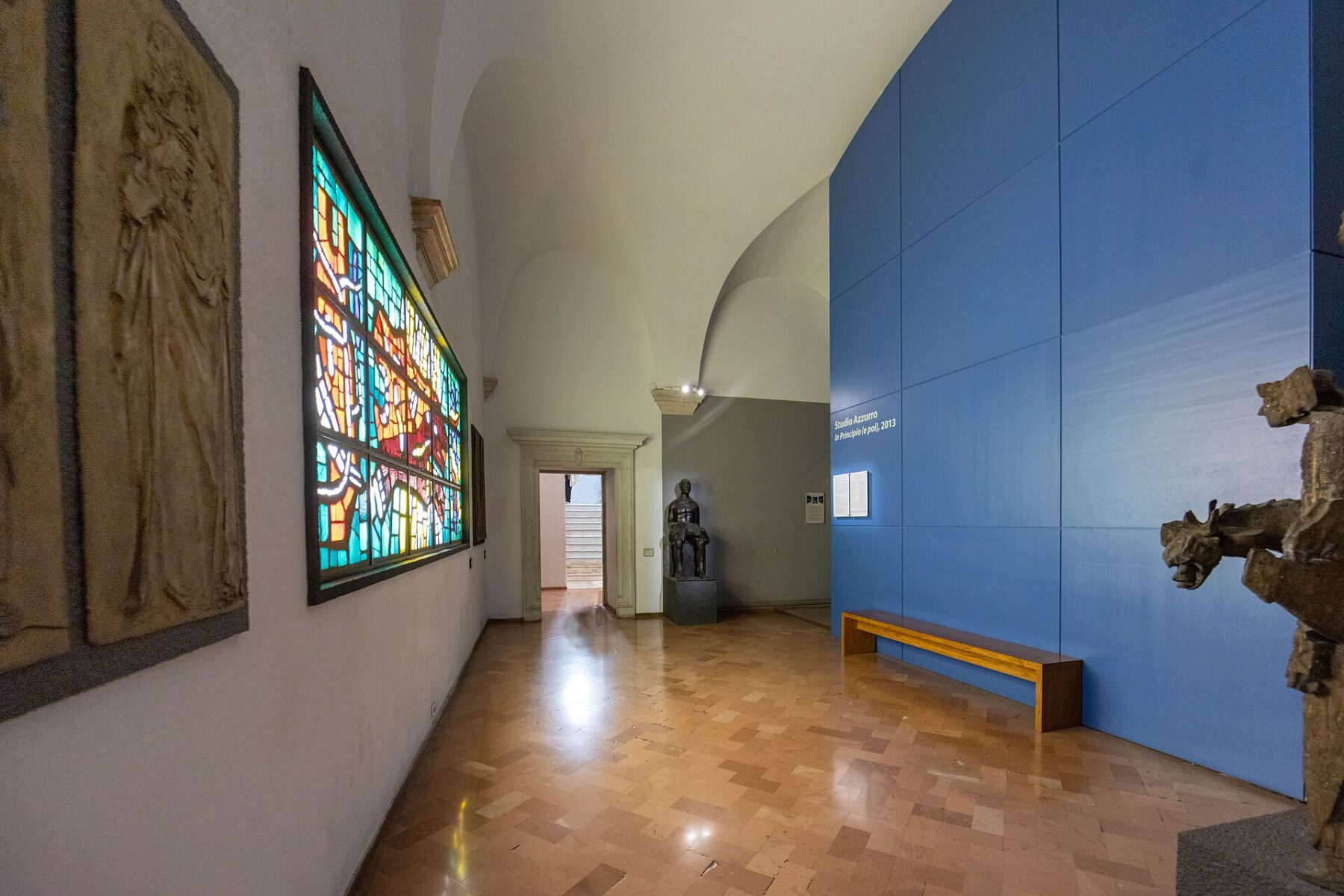 Sala museale scura con grandi schermi video e postazioni di pietra dell’installazione di Studio Azzurro.