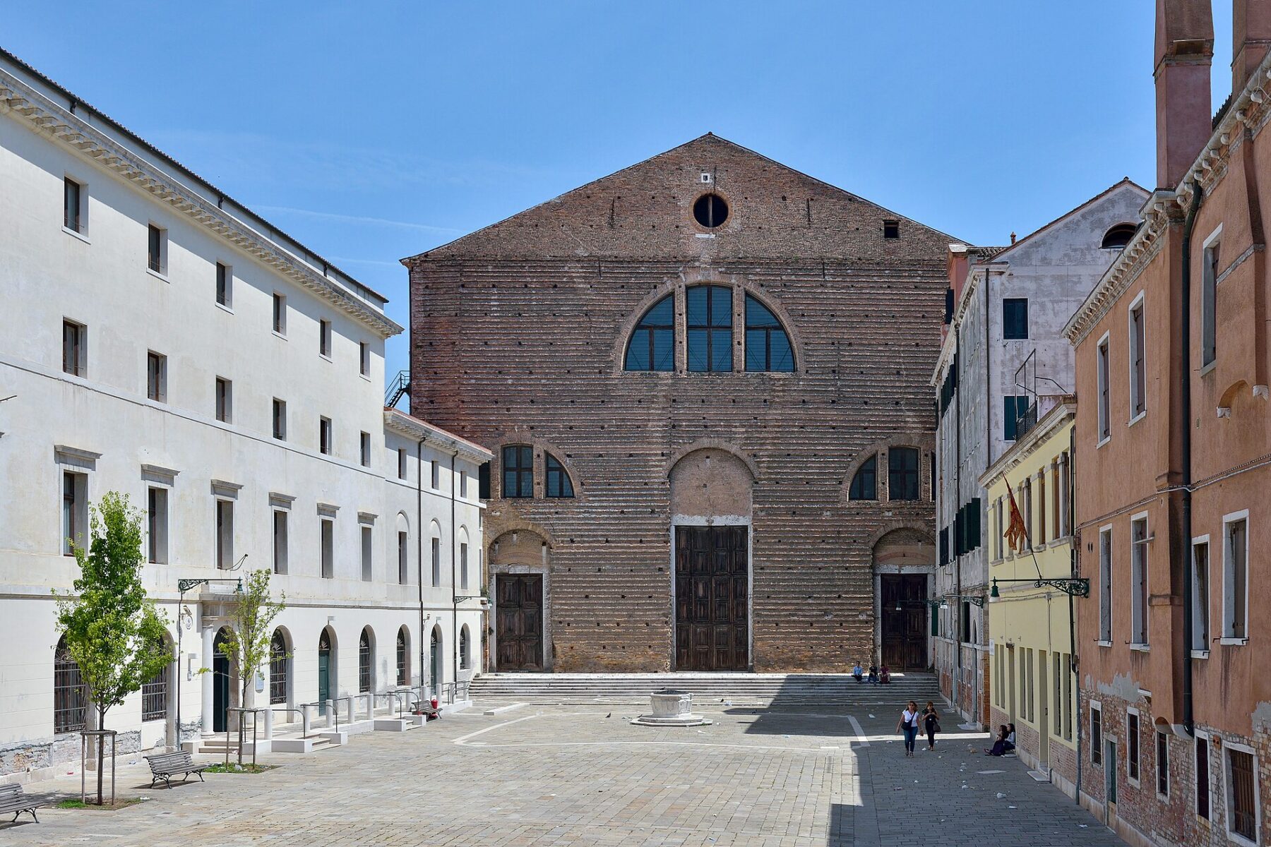 Veduta esterna della Chiesa di San Lorenzo a Venezia affacciata su un canale, sotto un cielo luminoso.