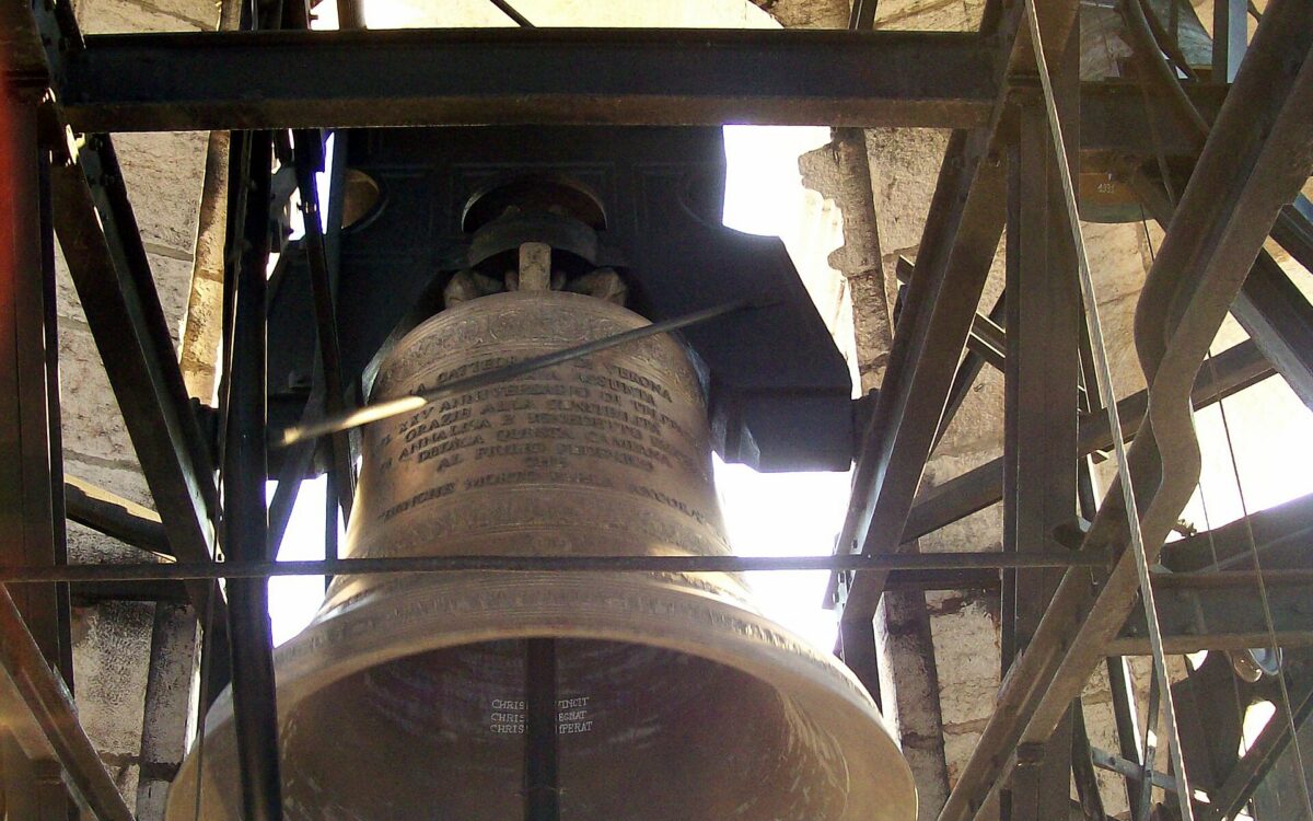 Grande campana in bronzo montata su una struttura di legno.