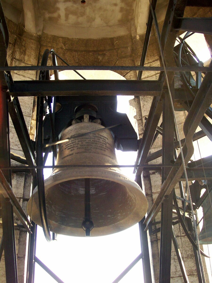 Grande campana in bronzo montata su una struttura di legno.